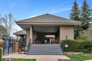Property entrance with roof with shingles and stucco siding