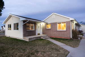 Bungalow featuring a front lawn and brick siding