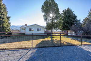 Single story home featuring a fenced backyard, a chimney, and a mountain view