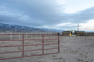 View of yard with a mountain view, an outdoor structure, a rural view, and an enclosed horse arena