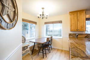 Dining area with light wood-style flooring and hanging lights