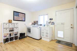 Laundry room featuring light wood-type flooring and washer and clothes dryer