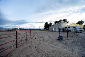 View of yard with an enclosed riding area and an outbuilding