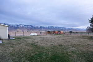 View of yard with a rural view, a mountain view, an outbuilding, and an exterior structure