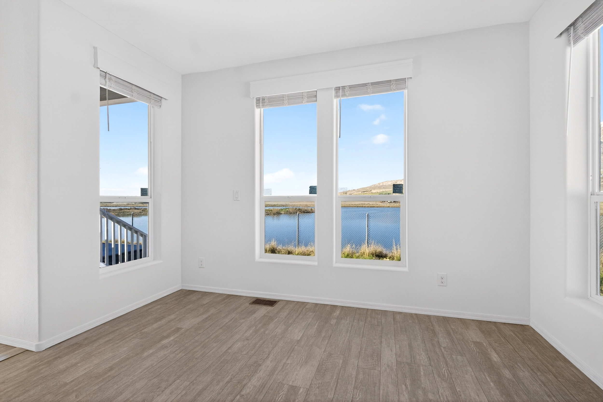 Empty room with a water view and wood finished floors