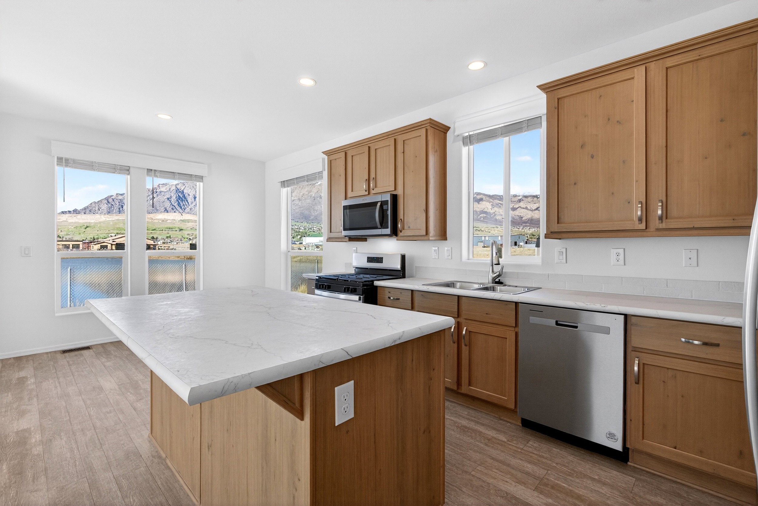 Kitchen with a mountain view, light countertops, stainless steel appliances, light wood-type flooring, and recessed lighting