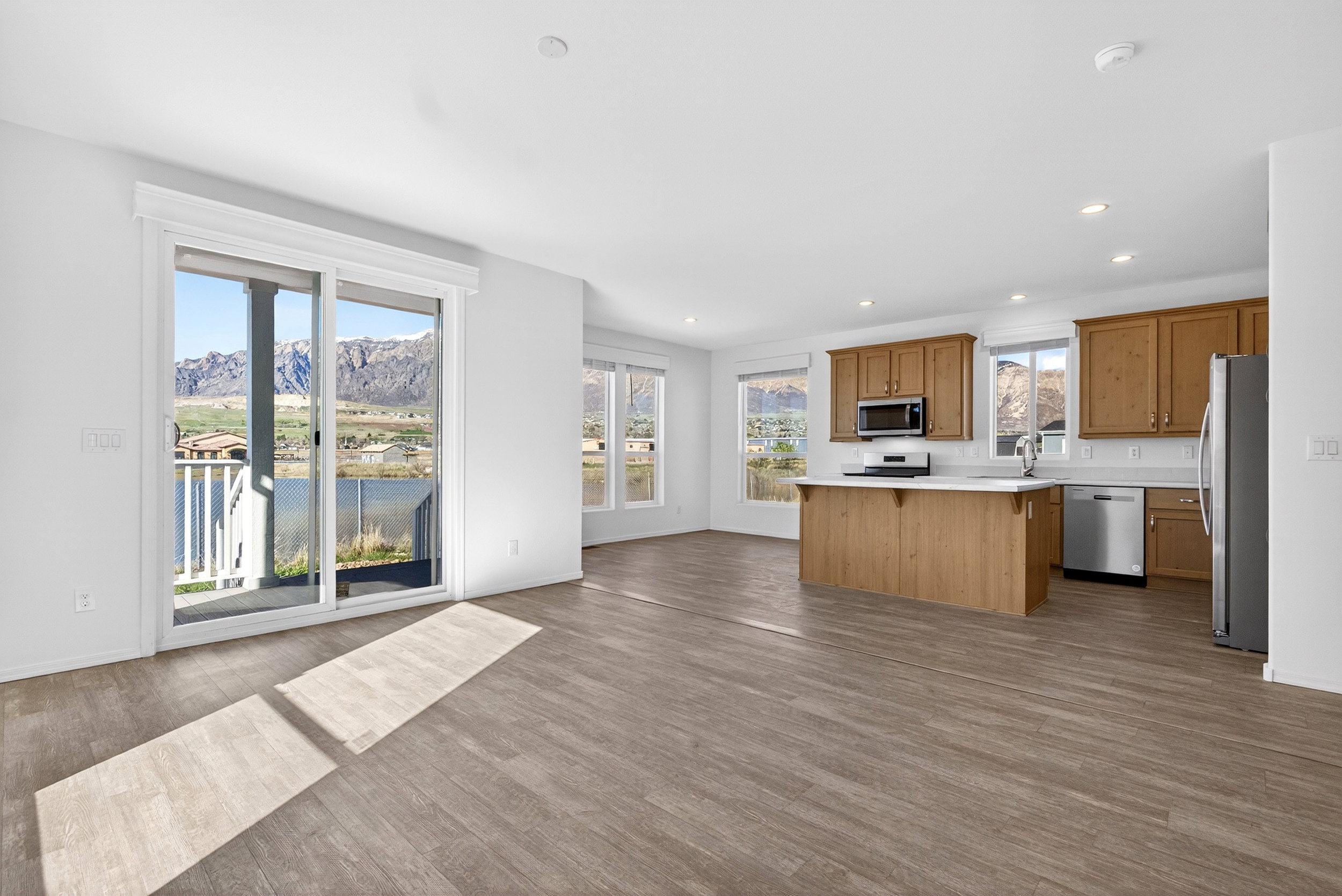Kitchen featuring light countertops, stainless steel appliances, wood finish cabinets, open floor plan, and a kitchen island