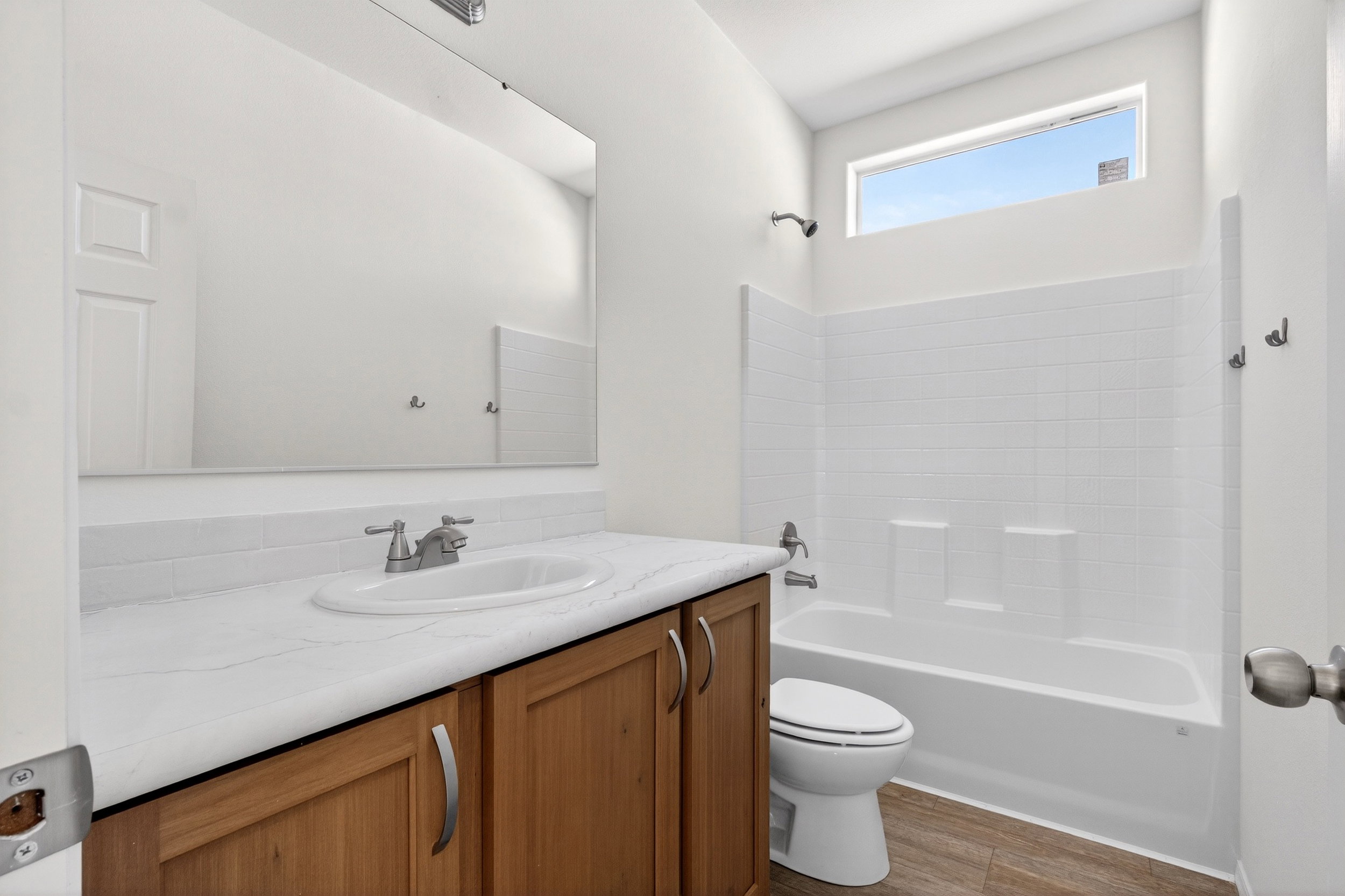 Bathroom featuring vanity, tub / shower combination, and wood finished floors