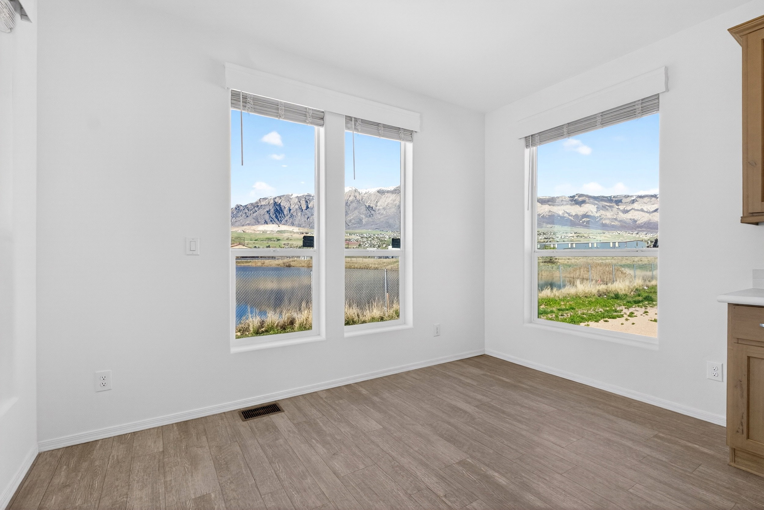 Unfurnished room featuring dark wood-style floors and a water and mountain view