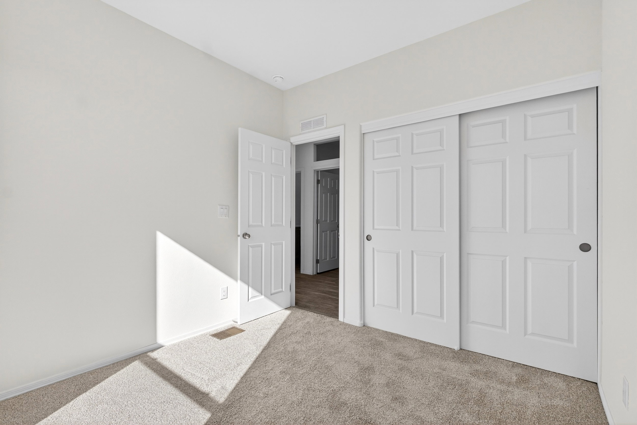 Unfurnished bedroom featuring light carpet and a closet