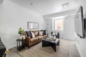 Living area featuring baseboards and light wood-style floors