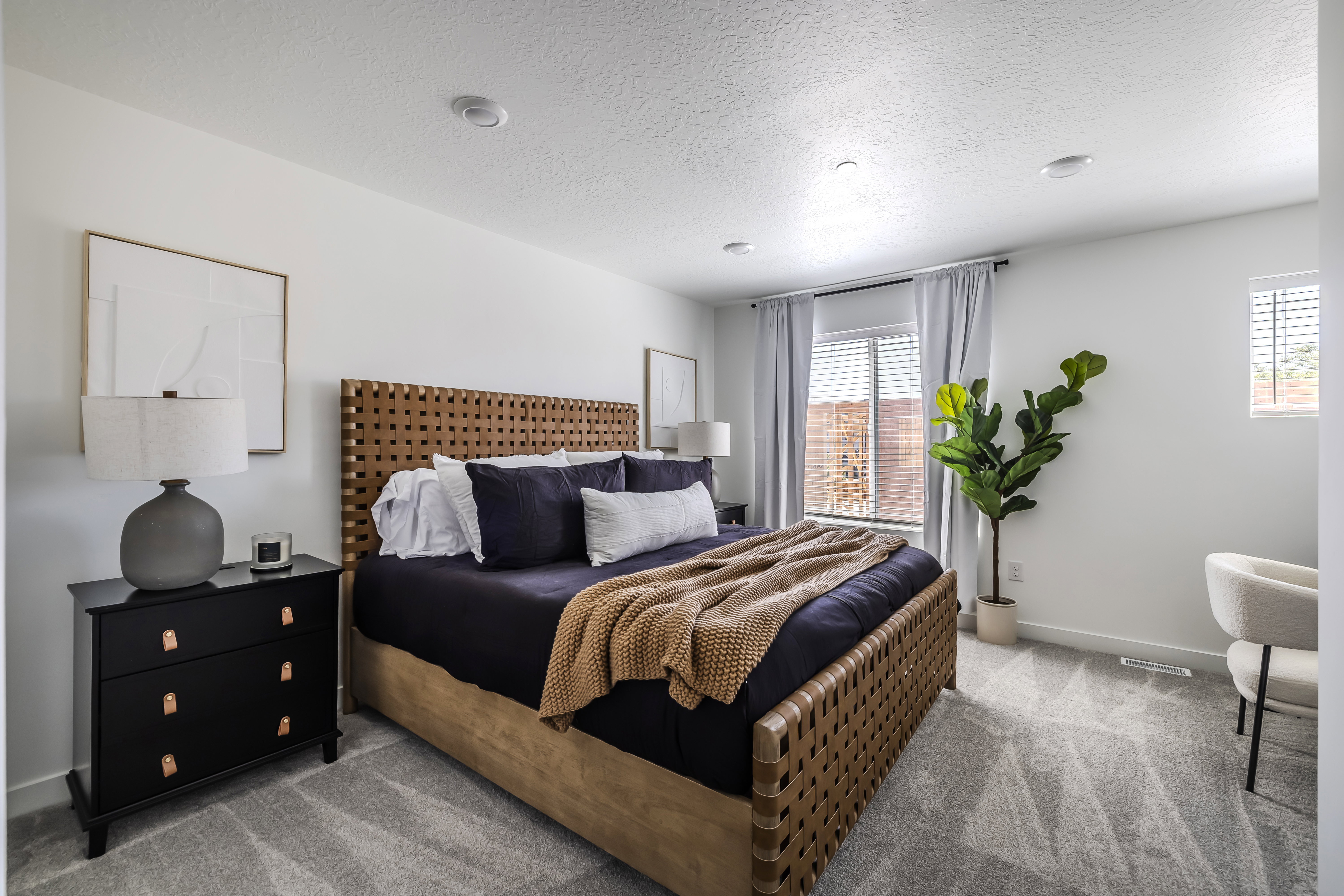 Bedroom featuring light colored carpet and a textured ceiling