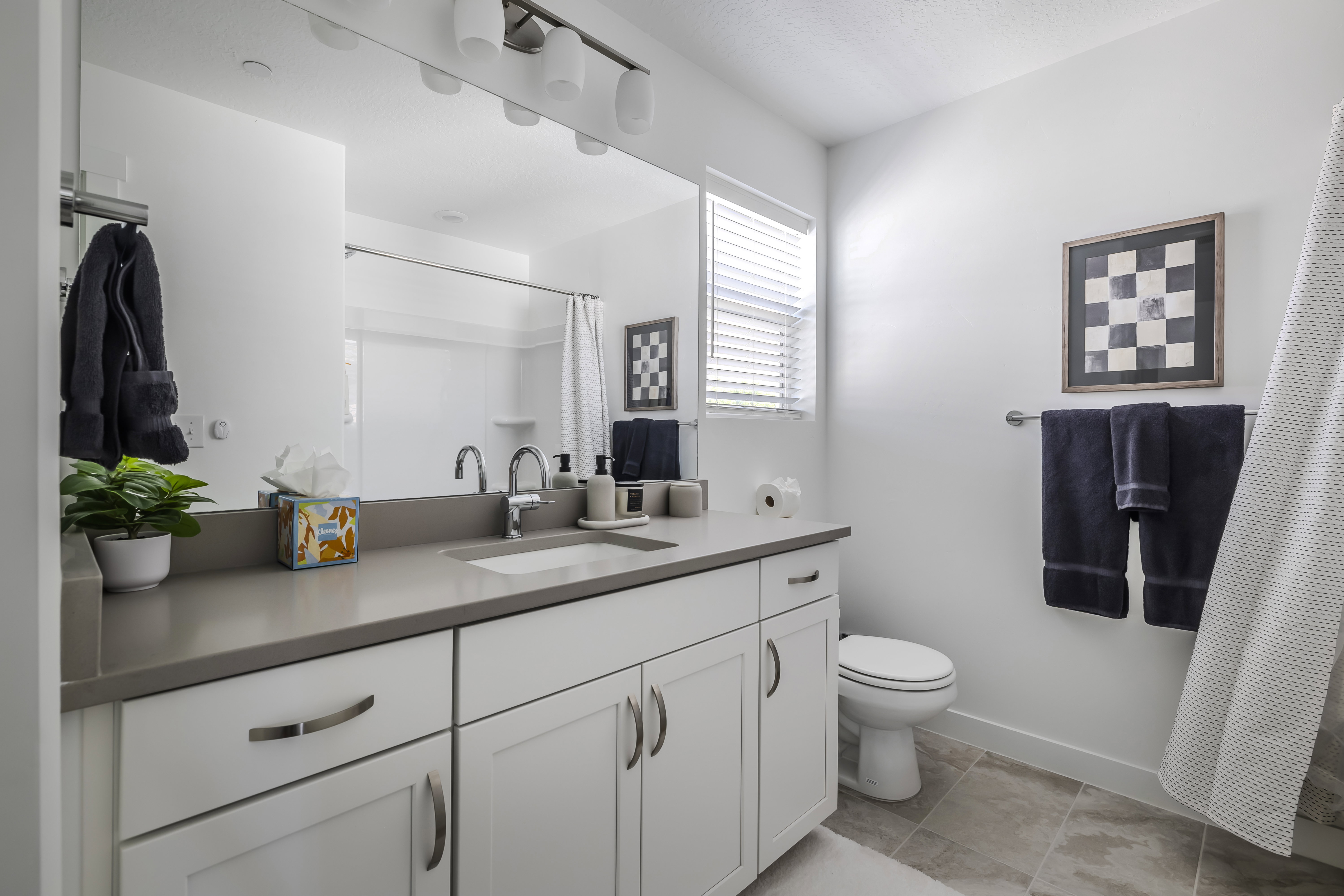 Bathroom with vanity, a shower with shower curtain, and light tile patterned floors