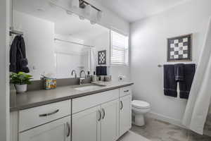Bathroom with vanity, a shower with shower curtain, and light tile patterned floors