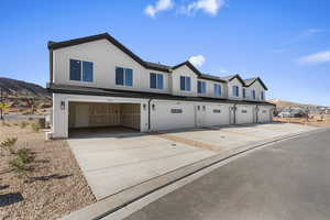Photos of similar home.View of front of home featuring a mountain view, stucco siding, a garage, and driveway