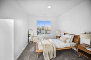 Bedroom featuring dark colored carpet and baseboards