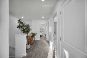 Corridor featuring an upstairs landing, recessed lighting, and light carpet