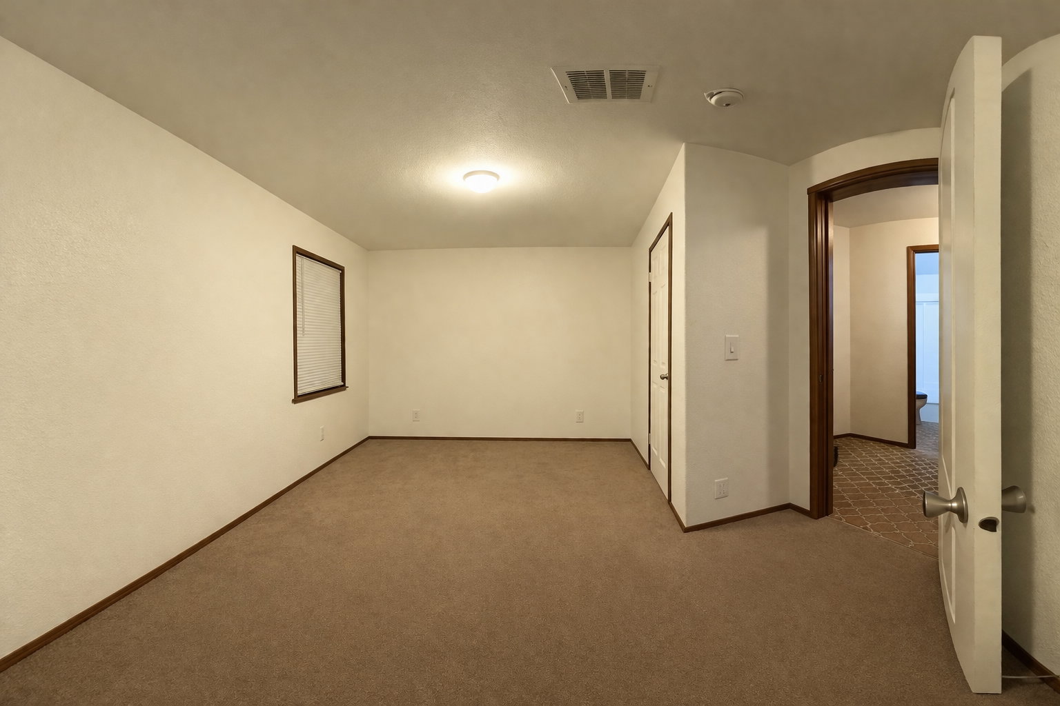Empty room with arched walkways and carpet floors