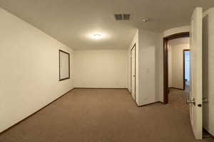 Empty room with arched walkways and carpet floors