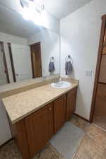 Bathroom with a textured wall and vanity