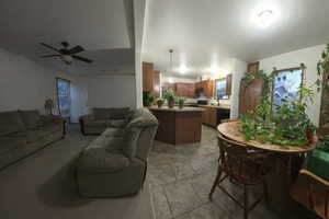 Living area with ceiling fan and light tile patterned floors