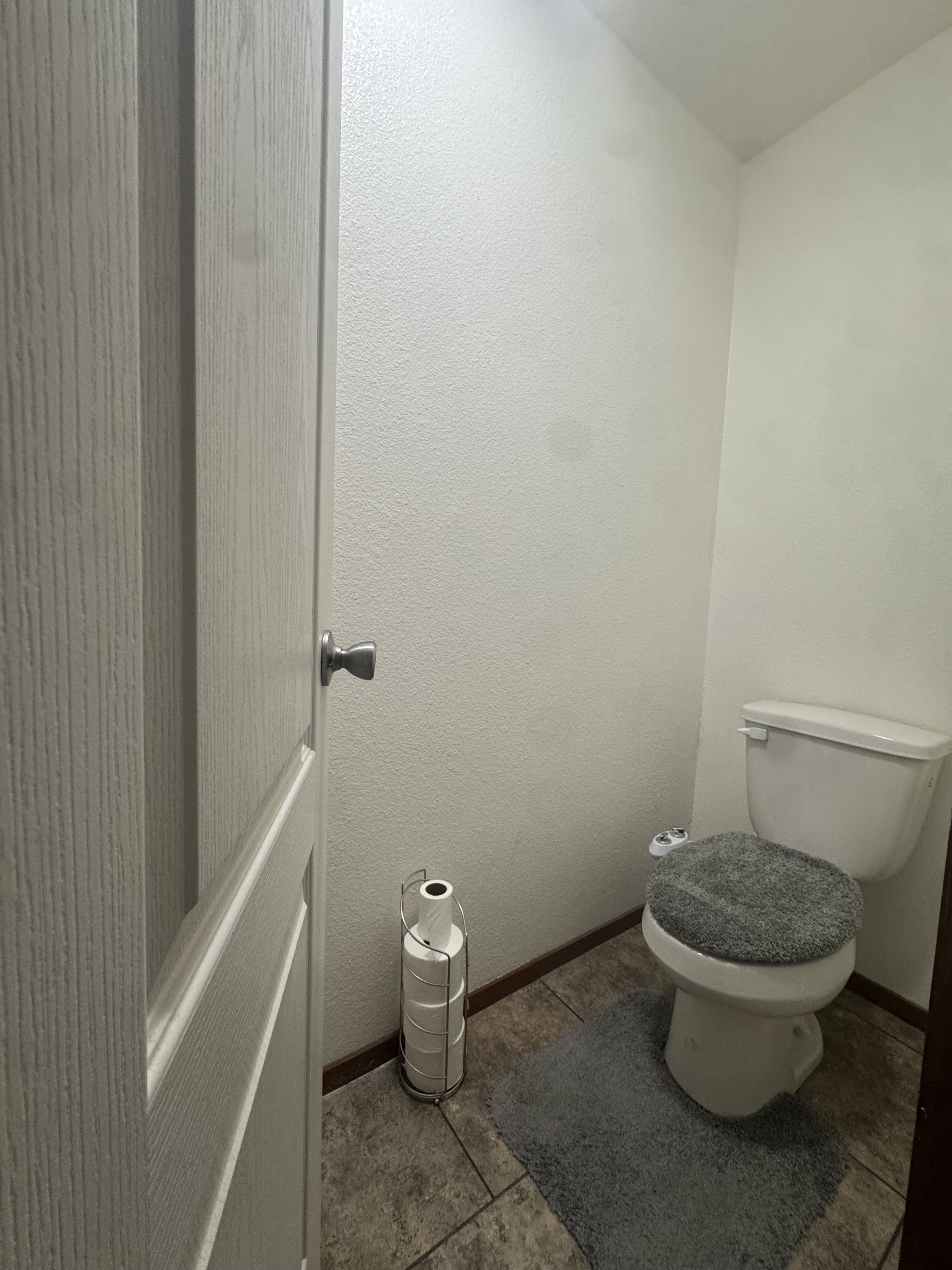 Bathroom featuring toilet and a textured wall