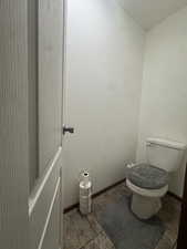 Bathroom featuring toilet and a textured wall