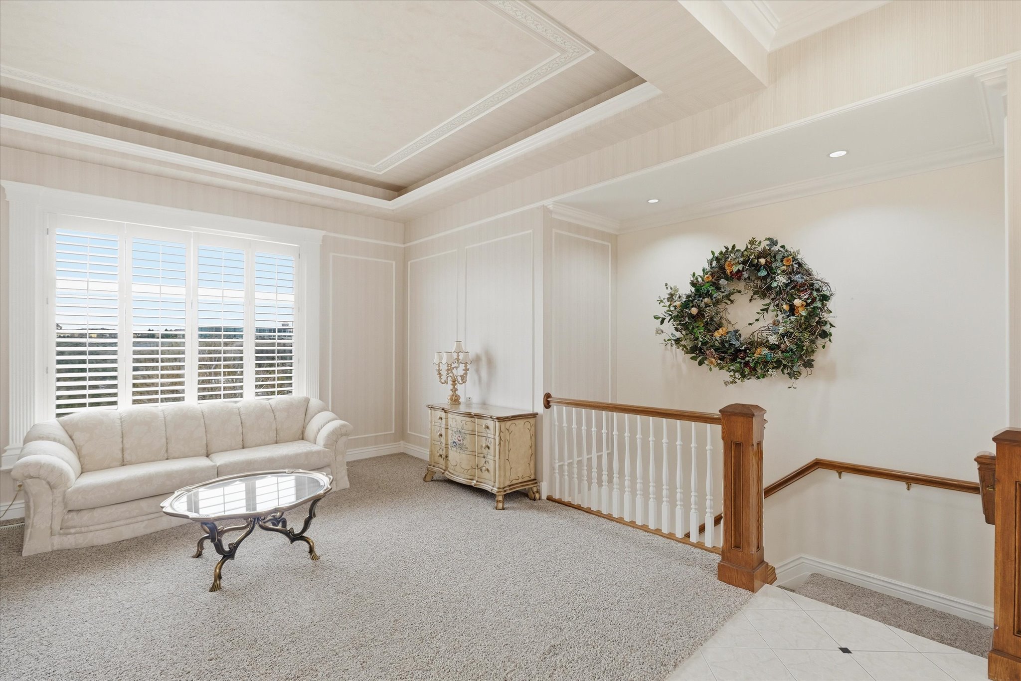 Living area featuring carpet, a tray ceiling, and ornamental molding