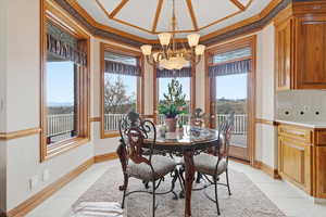 Dining room with hanging lights, crown molding, and light tile patterned flooring