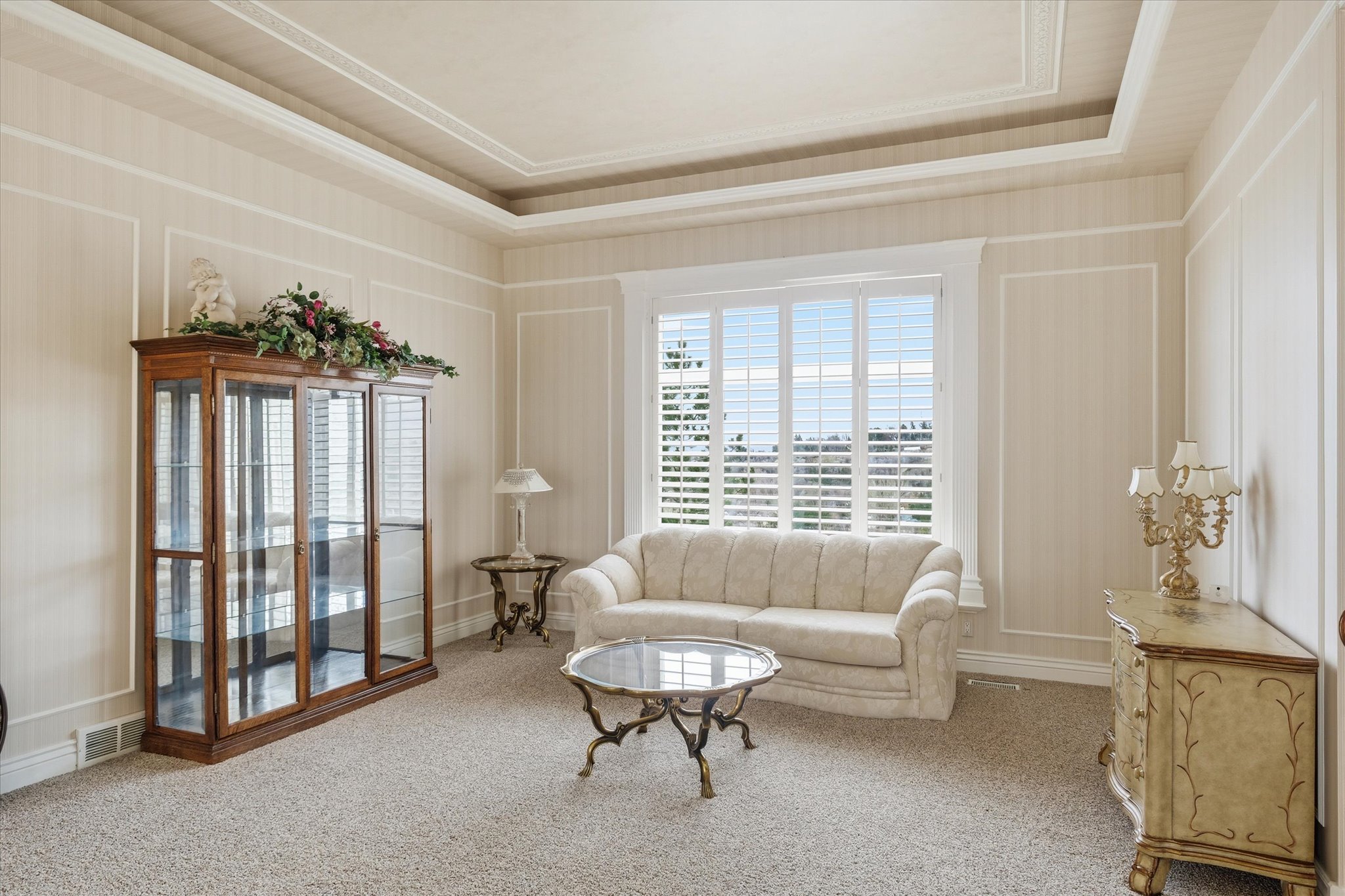 Living area with carpet floors and a tray ceiling