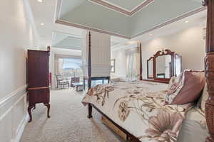 Bedroom with ornamental molding, light carpet, recessed lighting, a wainscoted wall, and a multi sided fireplace