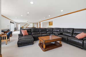 Living area featuring ornamental molding, light carpet, and recessed lighting