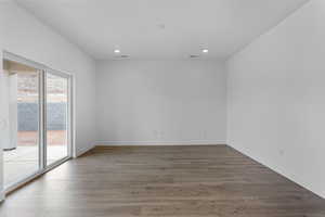 Empty room with dark wood finished floors and recessed lighting