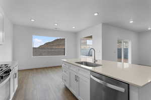 Kitchen with stainless steel appliances, white cabinets, dark wood-style floors, a kitchen island with sink, and recessed lighting