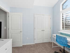 Home office with light carpet and baseboards