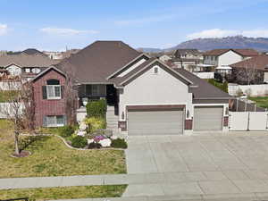 View of front of property featuring a residential view, brick siding, a garage, concrete driveway, and a gate
