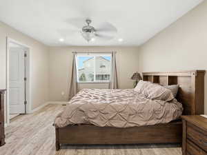 Bedroom with light wood-type flooring, ceiling fan, and recessed lighting