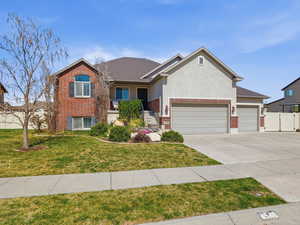 View of front of property featuring brick siding, a garage, a gate, and driveway