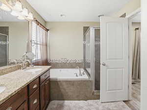 Bathroom with double vanity, a garden tub, and a shower stall