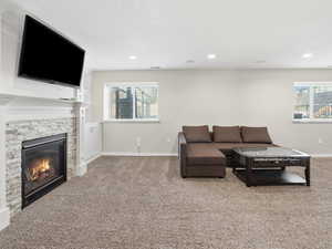 Living area featuring carpet floors, a fireplace, and recessed lighting