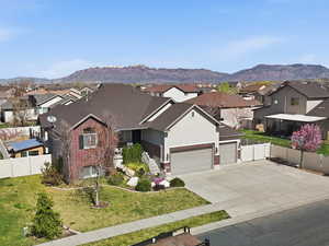 Traditional home featuring a residential view, a garage, a mountain view, and concrete driveway