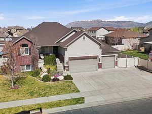 View of front of house with a residential view, an attached garage, a gate, brick siding, and driveway