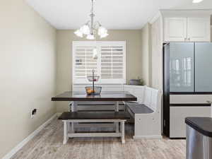 Dining space featuring hanging lights and light wood finished floors