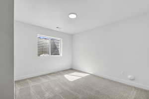 Unfurnished room with baseboards and light colored carpet