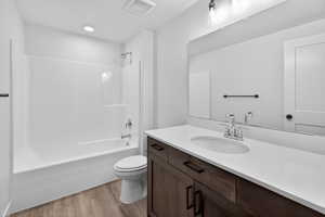 Full bath with vanity, light wood-type flooring, and  shower combination