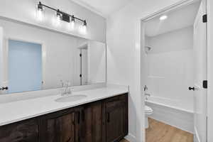 Full bath with vanity, light wood-style flooring, and  shower combination