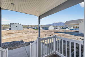 Covered porch with a mountain view and a residential view