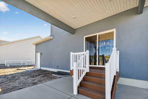 Doorway to property featuring a patio area and stucco siding