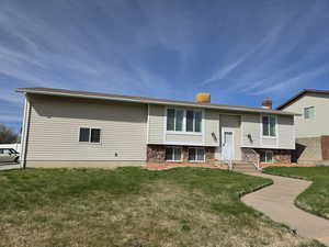 View of front of house with a front yard and a chimney