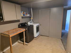 Laundry area with washing machine and dryer, finished concrete floors, and cabinet space